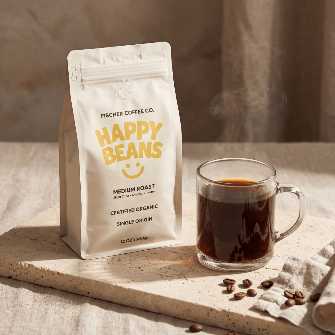 Fischer Coffee Co. 'Happy Beans' coffee package with a steaming cup of coffee on a textured surface.